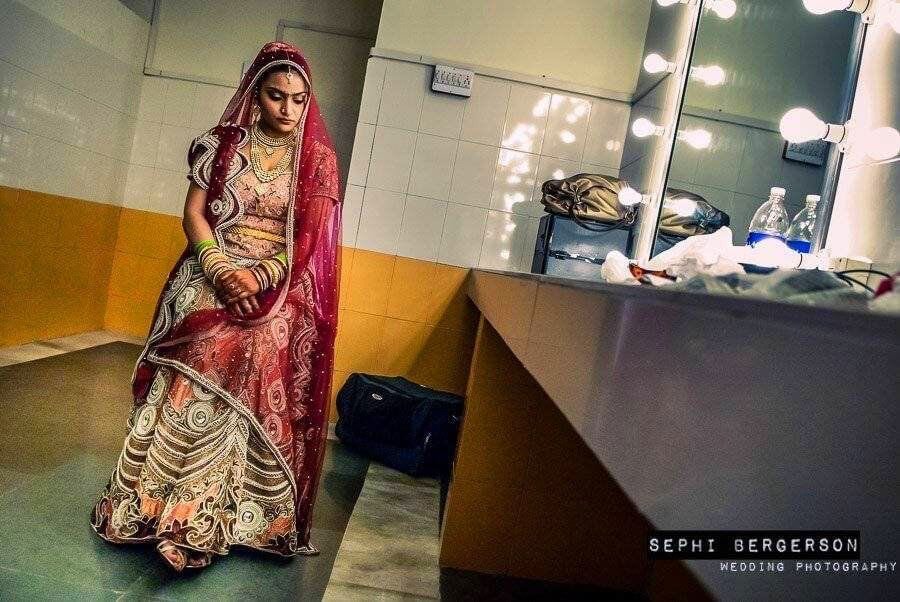 A quiet moment in the dressing room. A Rajput bride just before the wedding ceremony. Rajputs are instructed by the family members not to show any sign of happiness during their wedding and behave in a 'Royale' manner. There was not one smile during the entire wedding. To be true to the facts one must say that prior to the wedding itself, the Rajput bride danced in joy along with her relatives on her sangeet to a Bipasha Basu hit no. (Kanupriya & Ravindra's Rajput wedding in Gwalior)