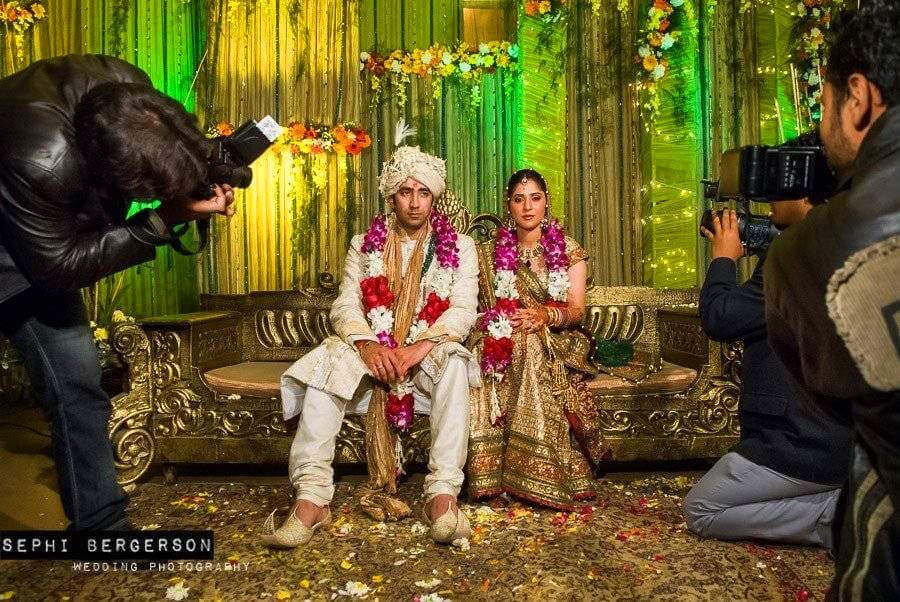 I loved the tired face of the couple waiting for the photogrtaphers to finish harassing them. A photo session like this takes place before the wedding and could sometime last close to two hours! The couple is seated on a podium and the entire family and guests come up to great them and have their picture taken. It was otherwise, a very happy wedding indeed. (Karishma & Rishabh's wedding in Delhi)